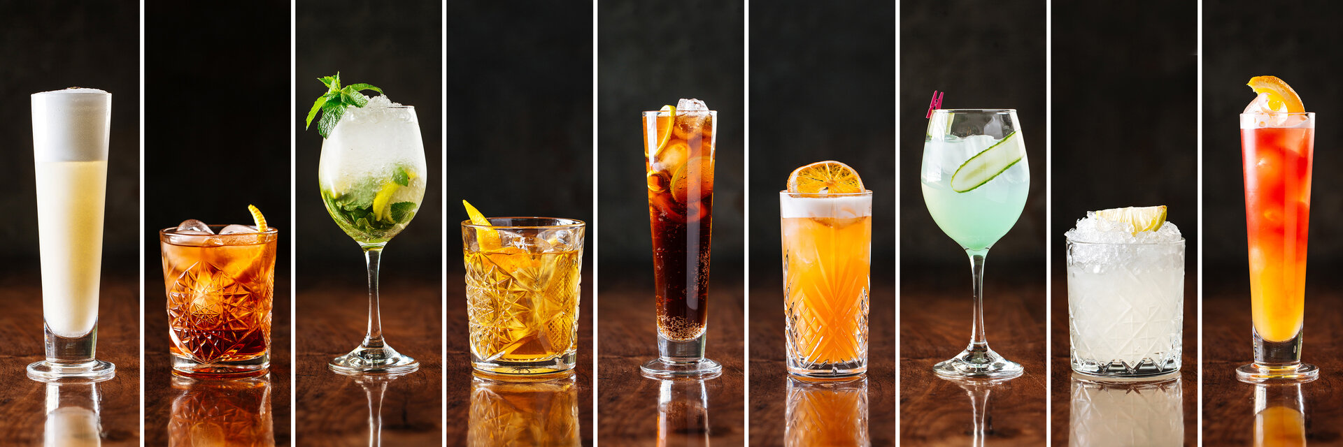 Horizontal sortierte Auswahl an süßen alkoholischen Cocktails in verschiedenen Gläsern.