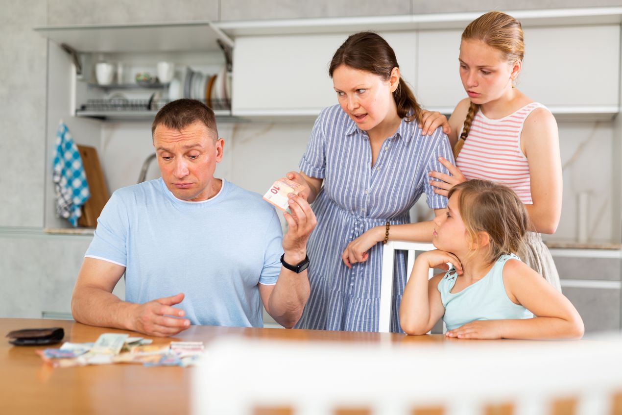 Eine Familie diskutiert angespannt am Küchentisch über das Haushaltsbudget – typisches Szenario beim Küche bestellen ohne klare Preisgrenze.