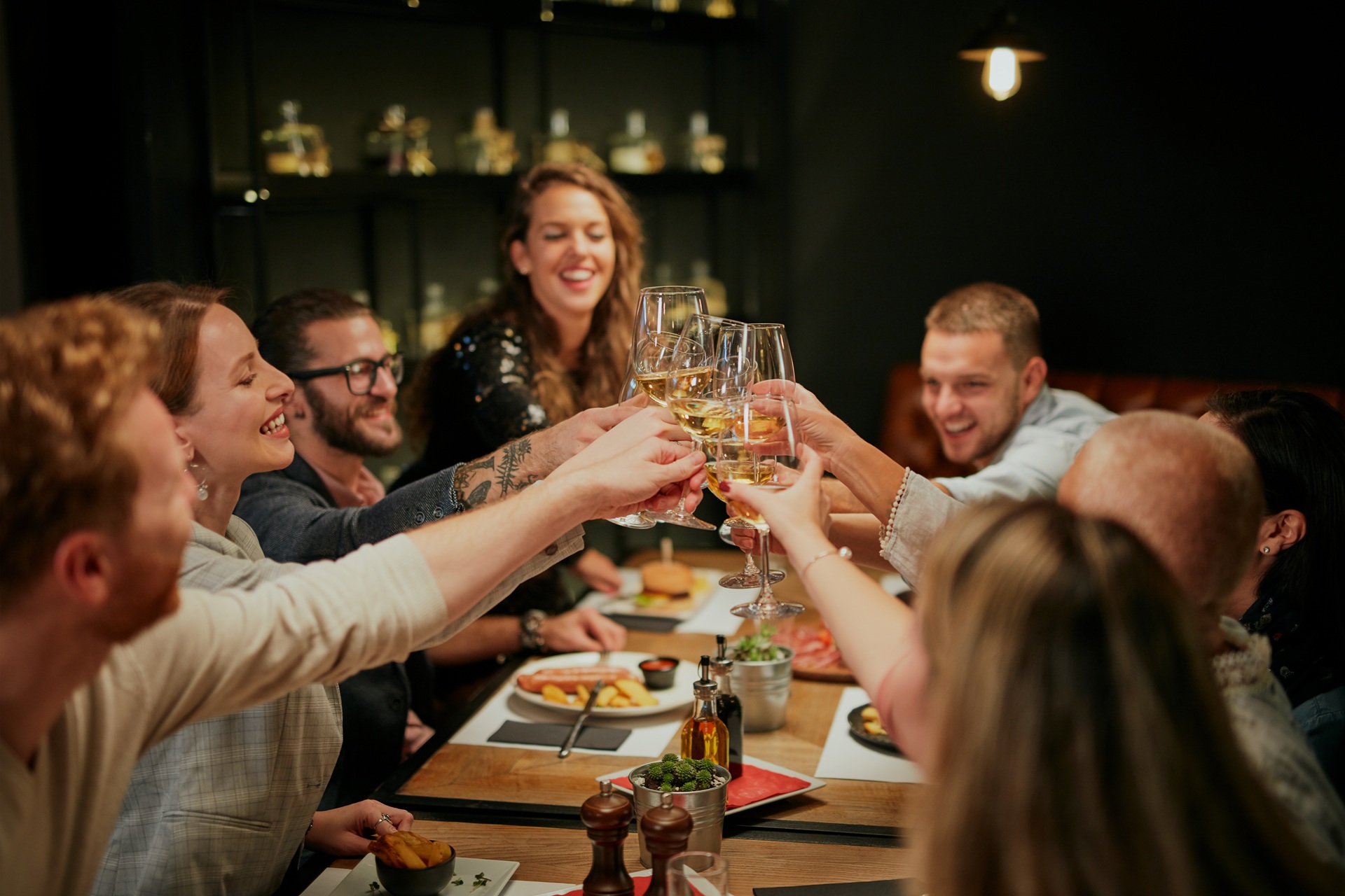 Freunde beim Anstoßen am Tisch | Dias digitalisieren lassen